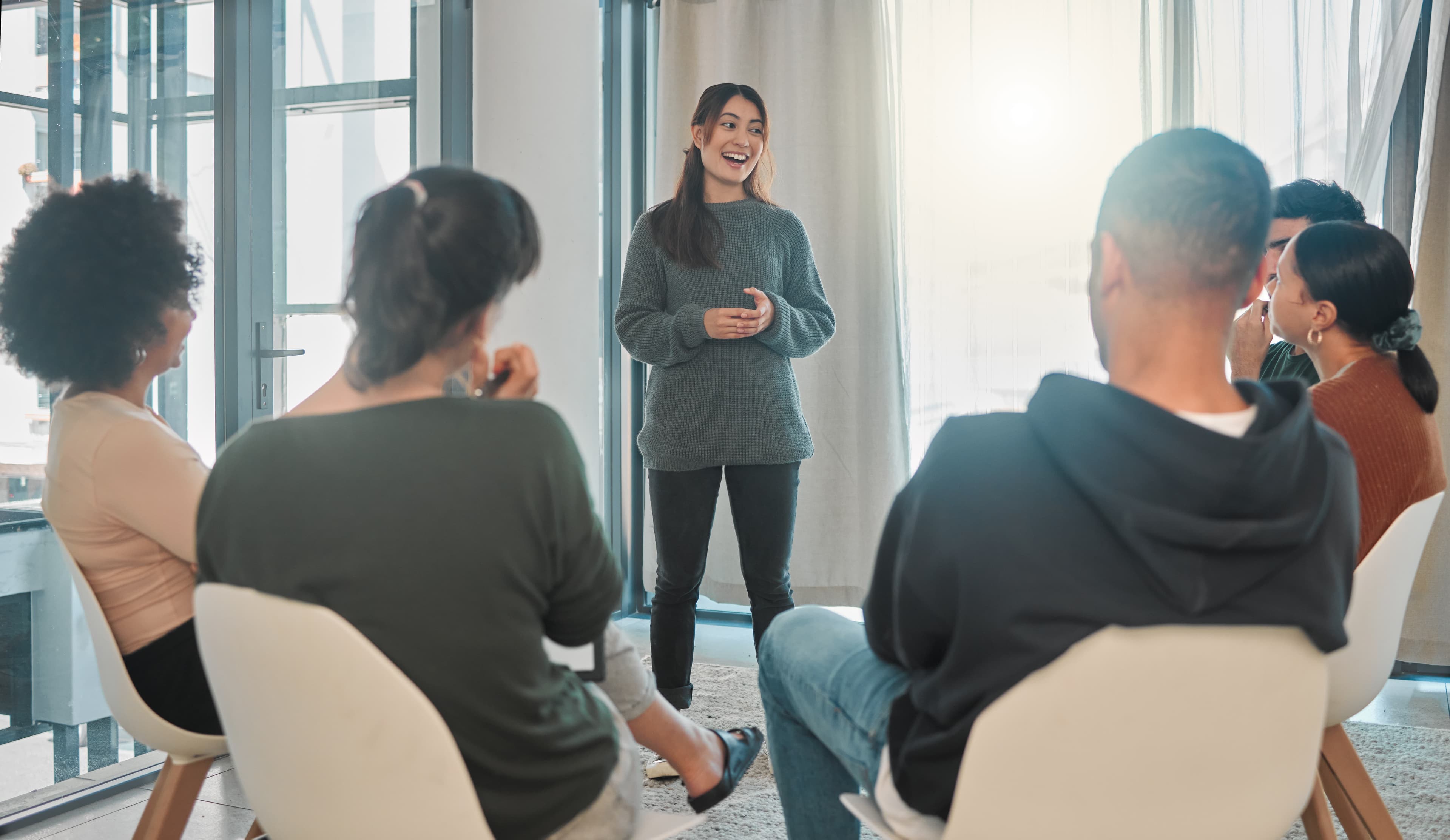 a group therapy circle with a young woman talking