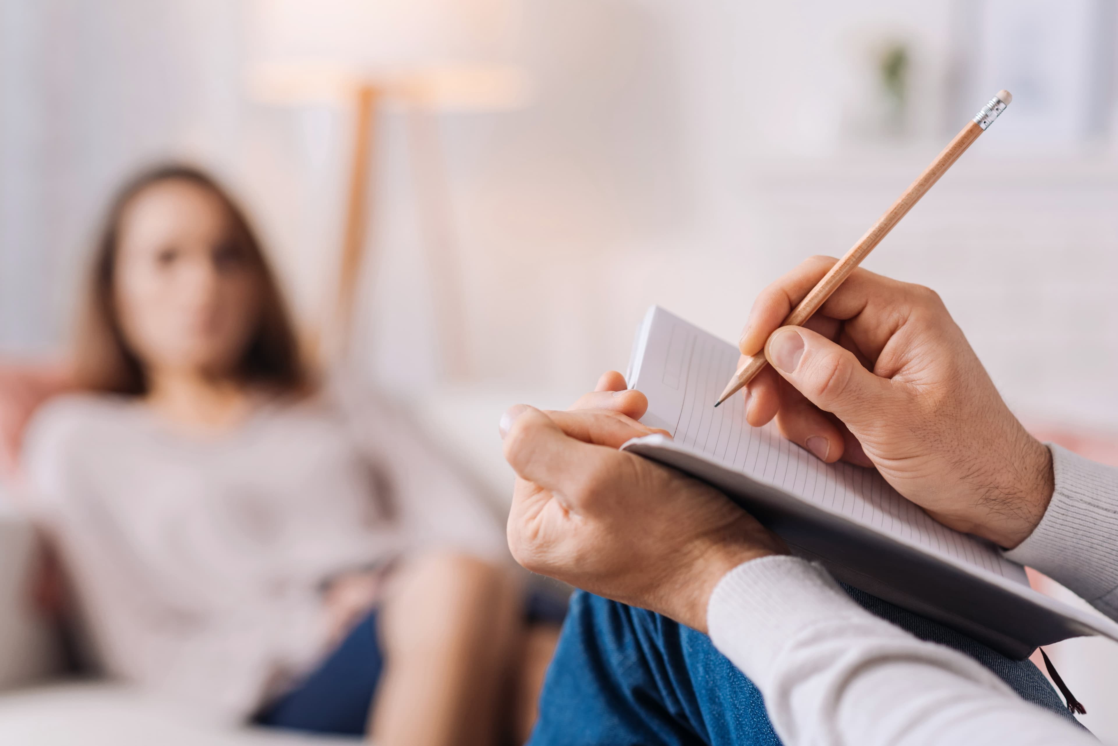 Counselor writing details in a notepad